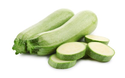 Photo of Fresh whole and cut zucchinis isolated on white