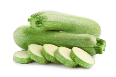 Photo of Fresh whole and cut zucchinis isolated on white