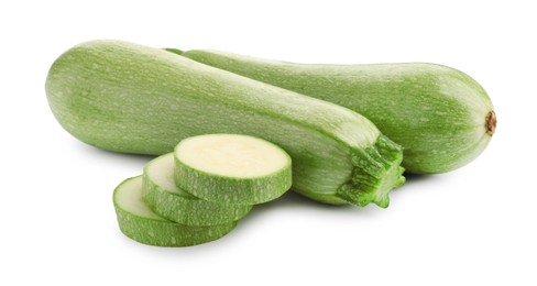 Photo of Fresh whole and cut zucchinis isolated on white