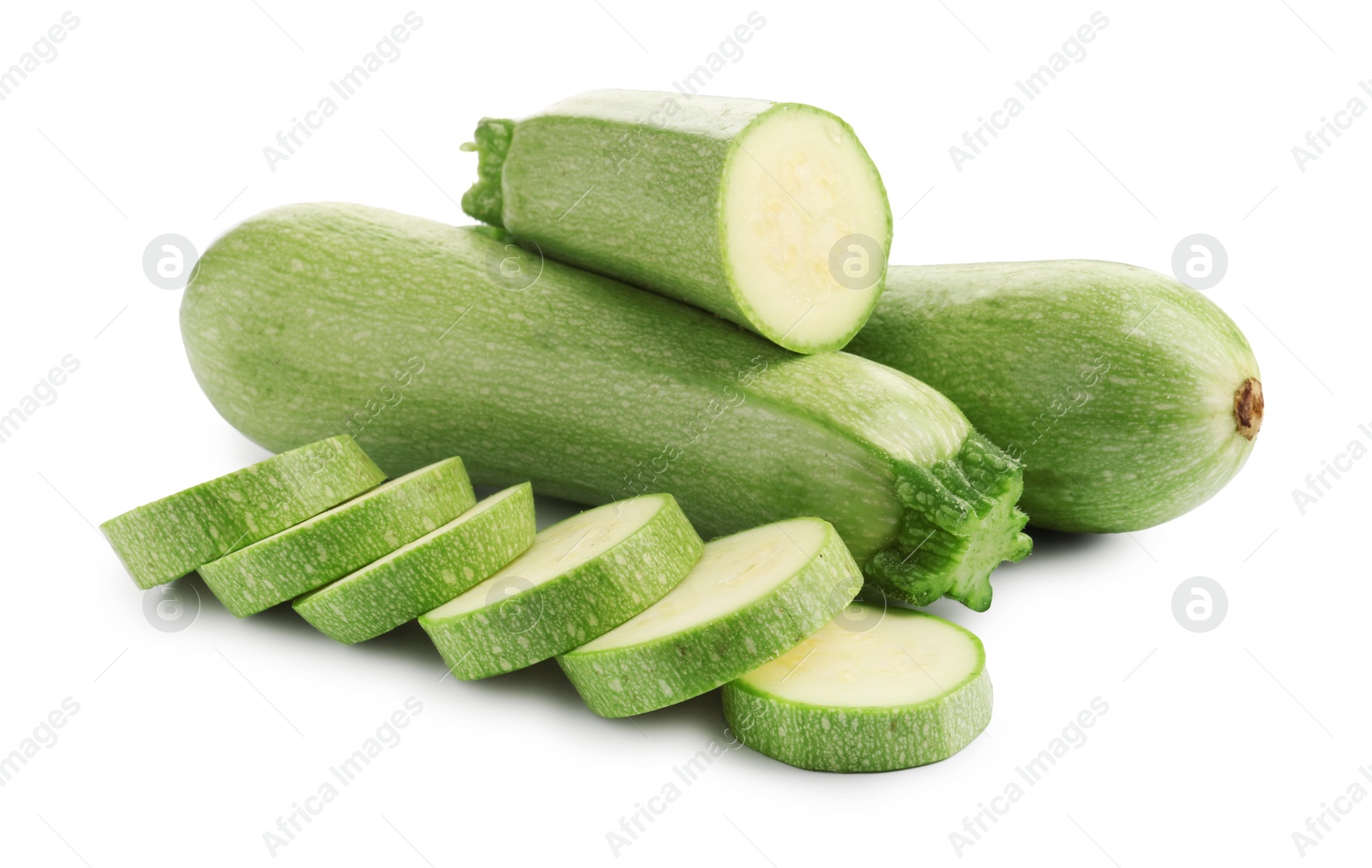 Photo of Fresh whole and cut zucchinis isolated on white