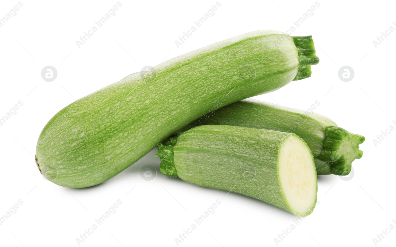 Photo of Fresh whole and cut zucchinis isolated on white