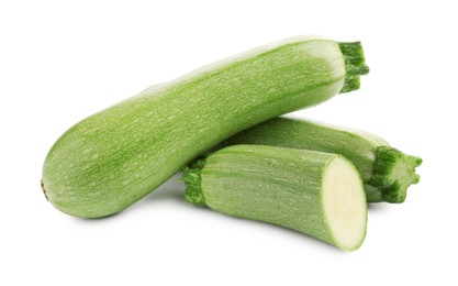 Photo of Fresh whole and cut zucchinis isolated on white