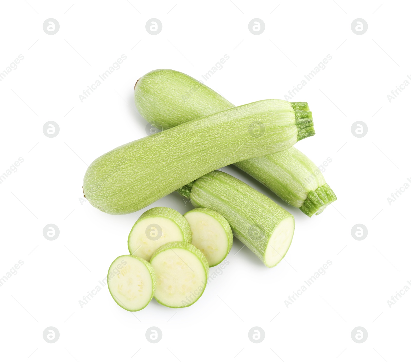 Photo of Fresh whole and cut zucchinis isolated on white, above view