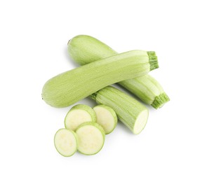 Photo of Fresh whole and cut zucchinis isolated on white, above view