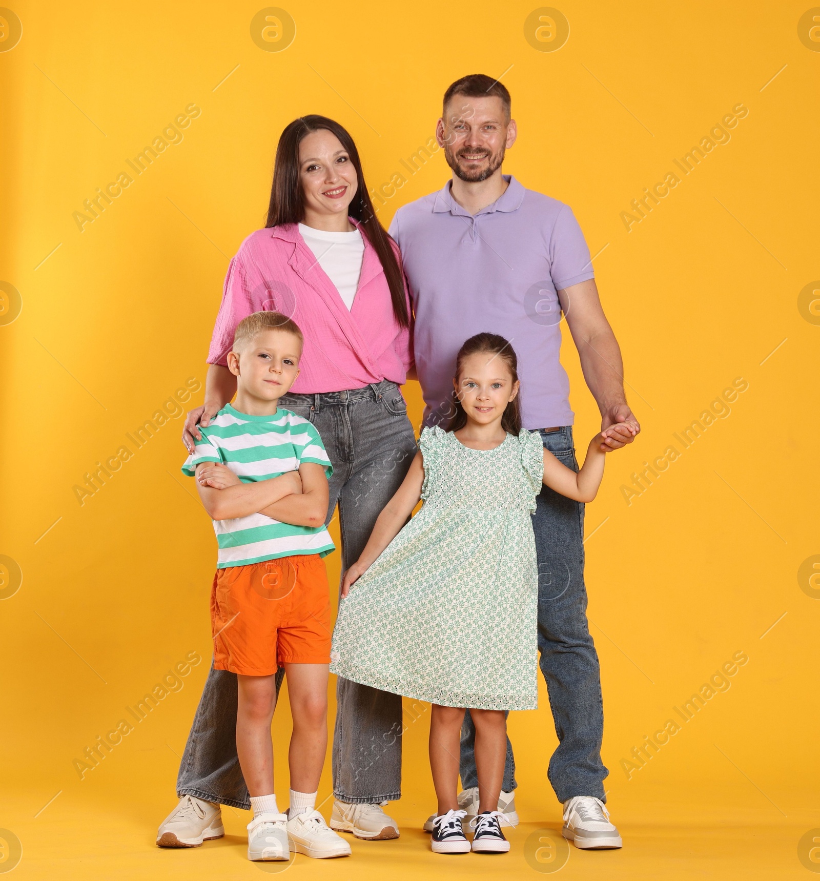 Photo of Lovely family posing together on yellow background