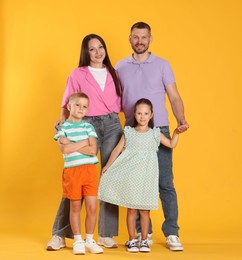Photo of Lovely family posing together on yellow background