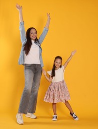 Photo of Mother and daughter having fun on yellow background