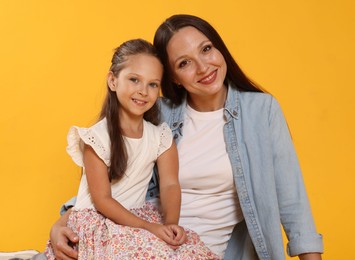 Photo of Lovely mother and daughter on yellow background
