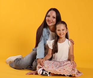 Photo of Lovely mother and daughter on yellow background