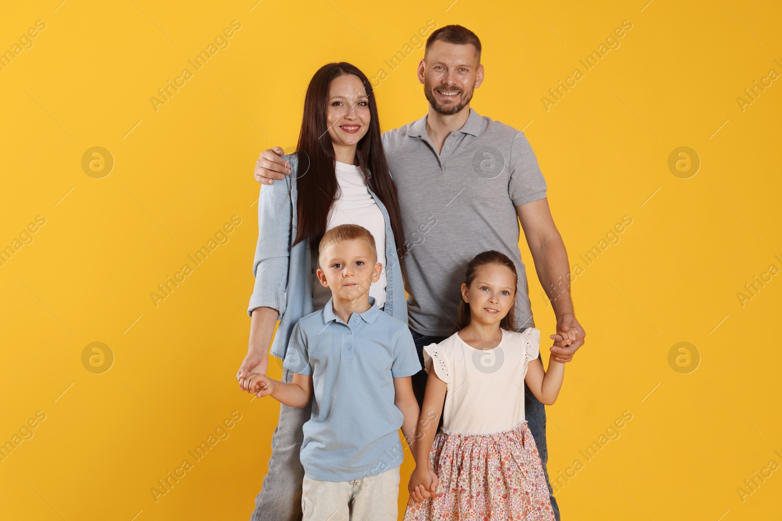 Photo of Portrait of happy family on yellow background