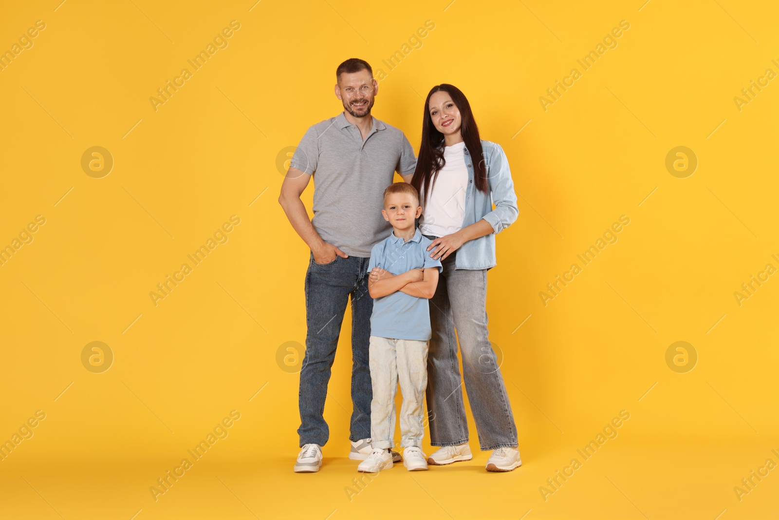 Photo of Lovely family posing together on yellow background