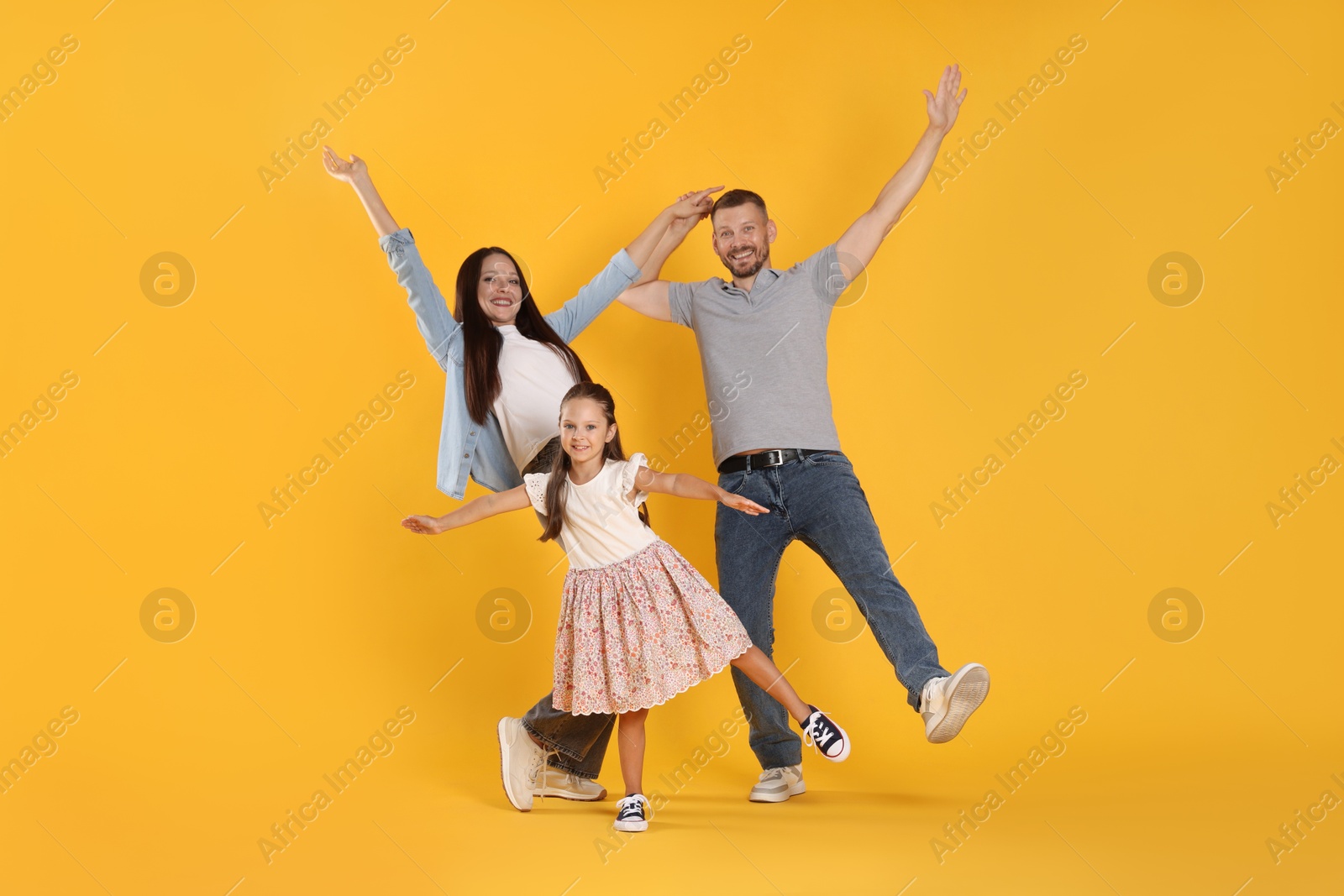 Happy family having fun on yellow background Photo of Happy family having fun on yellow background