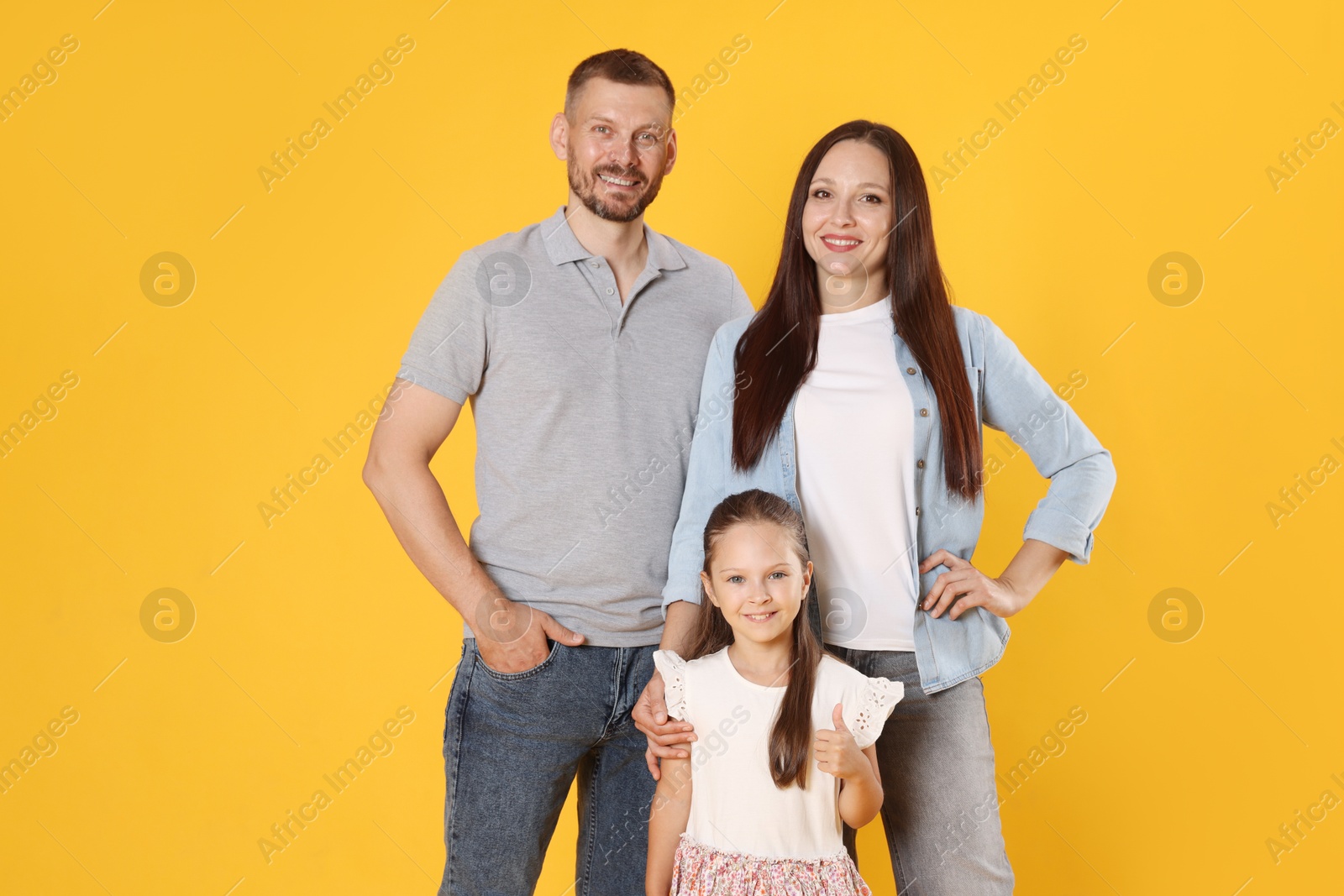 Portrait of happy family on yellow background Photo of Portrait of happy family on yellow background