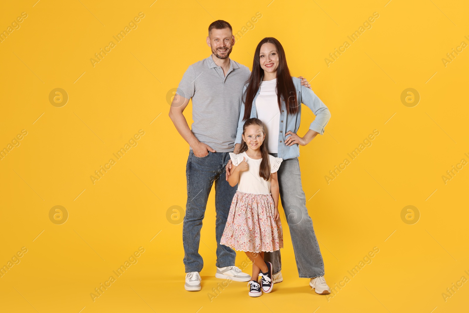 Photo of Lovely family posing together on yellow background