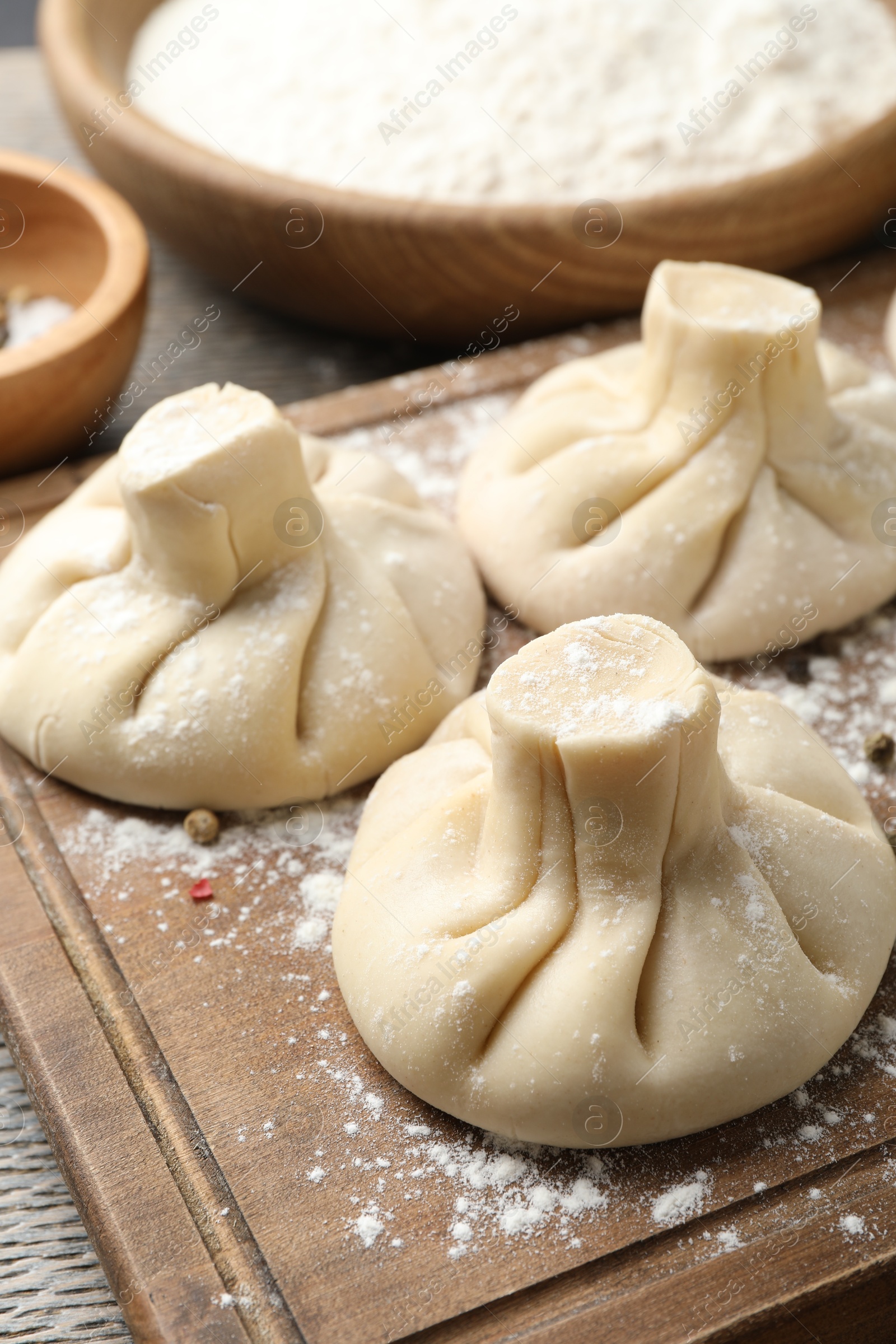 Uncooked khinkalis (dumplings) on wooden table, closeup Photo of Uncooked khinkalis (dumplings) on wooden table, closeup