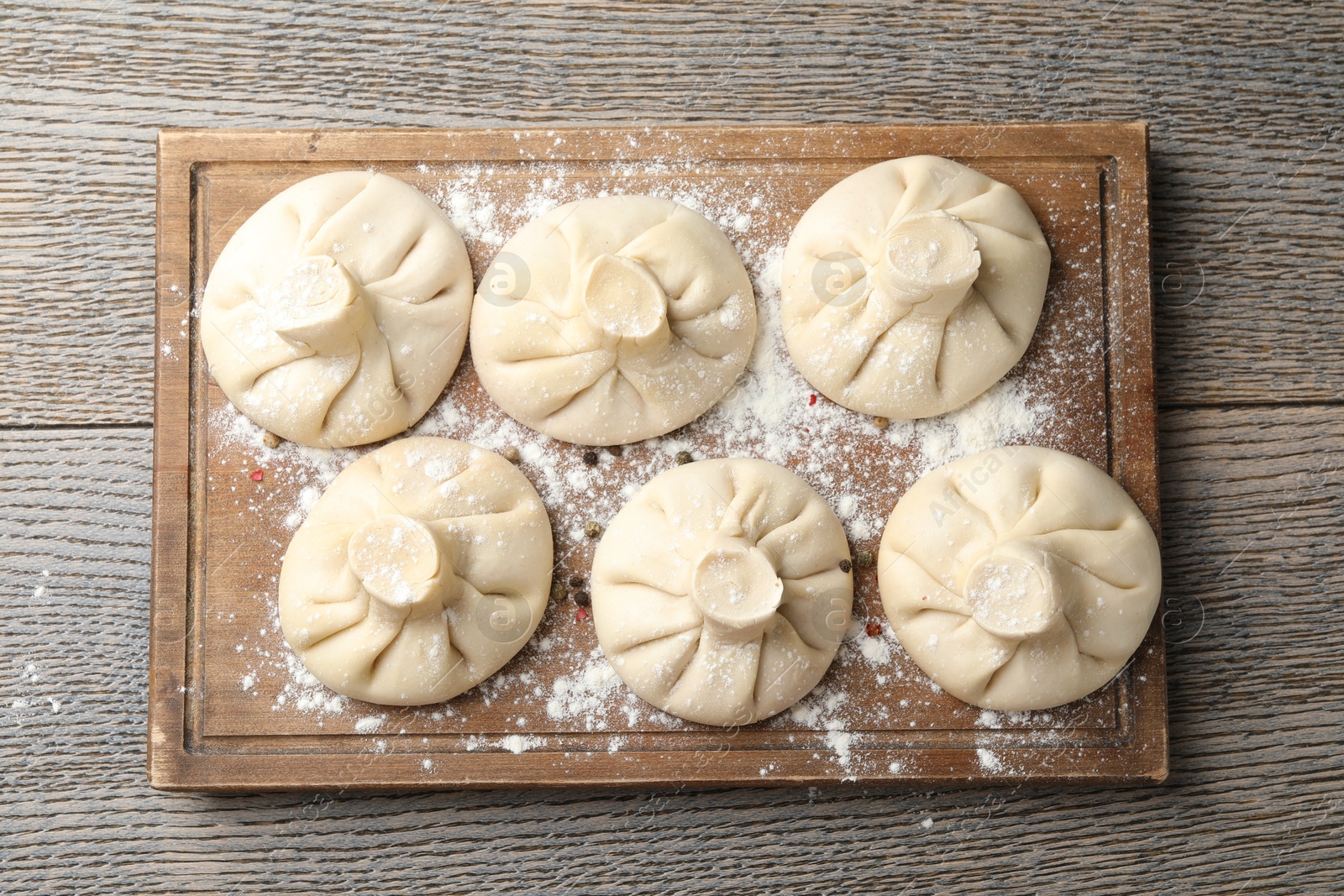 Uncooked khinkalis (dumplings) on wooden table, top view Photo of Uncooked khinkalis (dumplings) on wooden table, top view