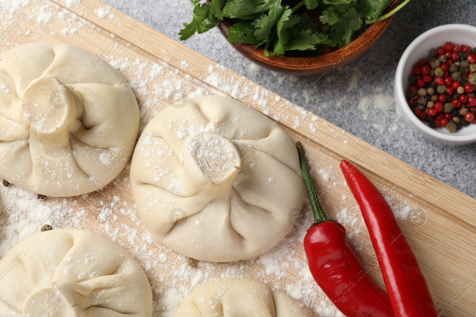 Uncooked khinkalis (dumplings) and spices on light grey table, flat lay Photo of Uncooked khinkalis (dumplings) and spices on light grey table, flat lay