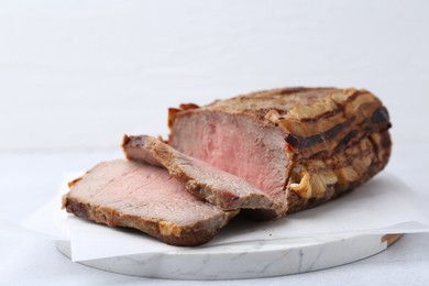 Photo of Delicious baked beef meat on light table, closeup