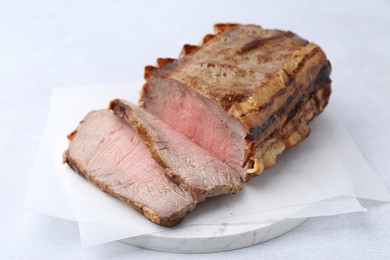Photo of Delicious baked beef meat on light table, closeup