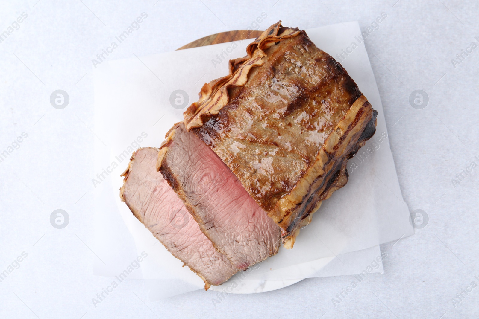 Delicious baked beef meat on light table, top view Photo of Delicious baked beef meat on light table, top view