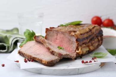 Photo of Delicious baked beef meat and spices on light table, closeup