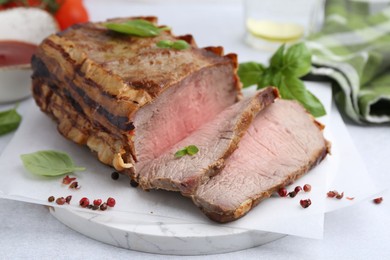 Photo of Delicious baked beef meat and spices on light table, closeup