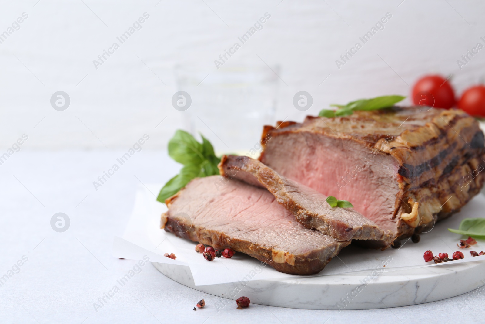 Delicious baked beef meat and spices on light table, closeup. Space for text Photo of Delicious baked beef meat and spices on light table, closeup. Space for text