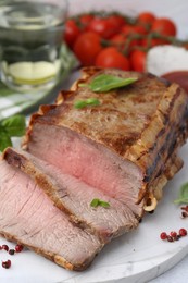 Photo of Delicious baked beef meat, spices and tomatoes on table, closeup