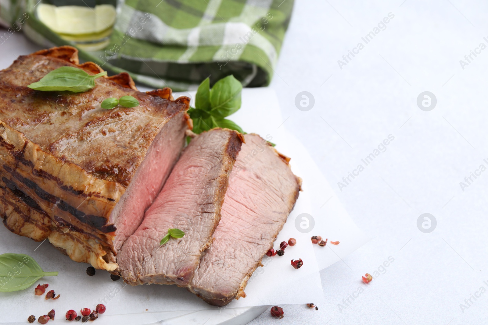 Delicious baked beef meat and spices on light table, closeup. Space for text Photo of Delicious baked beef meat and spices on light table, closeup. Space for text