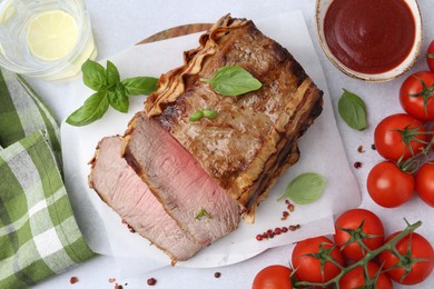 Photo of Delicious baked beef meat, tomatoes, spices and water with lime on light table, flat lay
