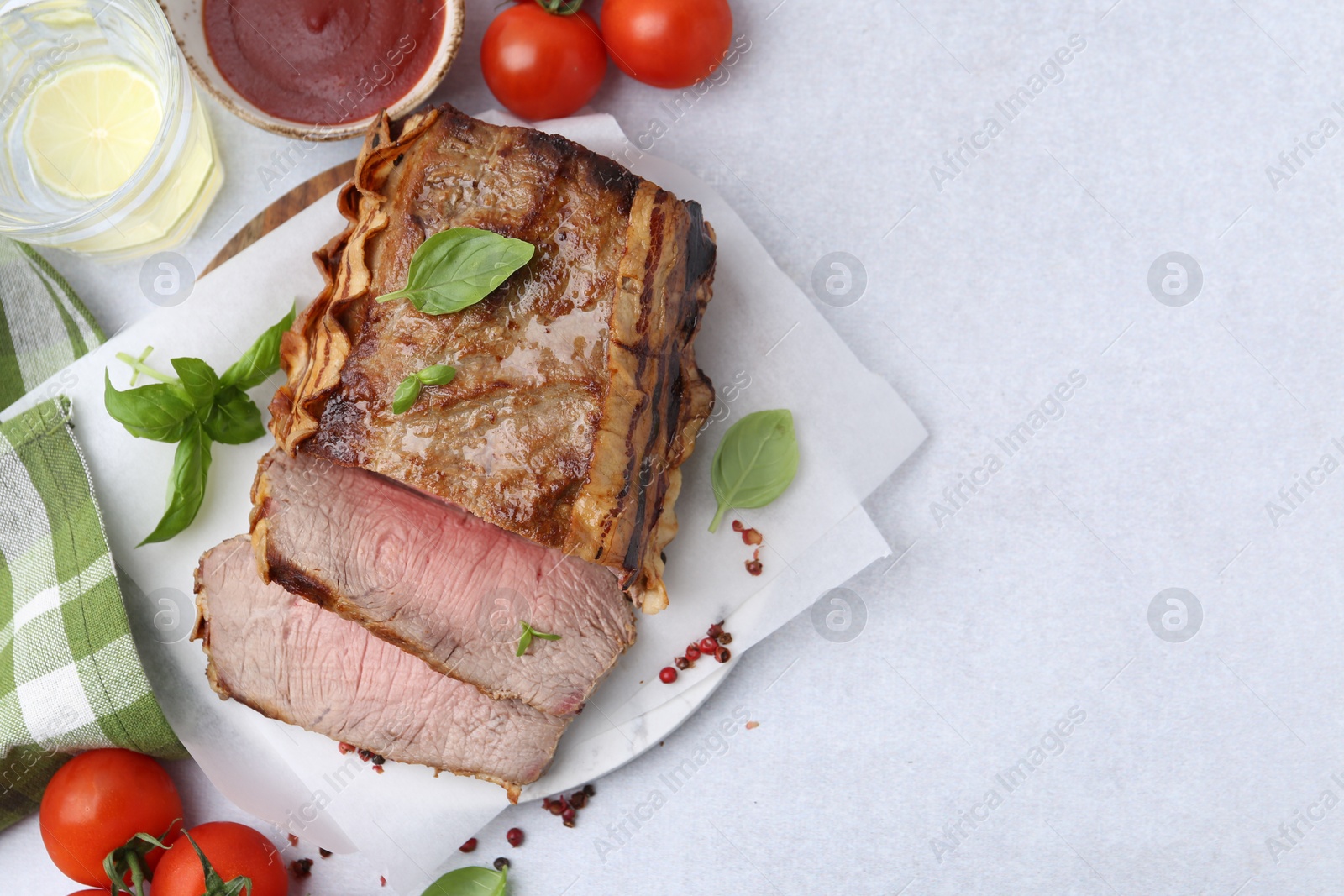 Delicious baked beef meat, tomatoes, spices and water with lime on light table, flat lay. Space for text Photo of Delicious baked beef meat, tomatoes, spices and water with lime on light table, flat lay. Space for text