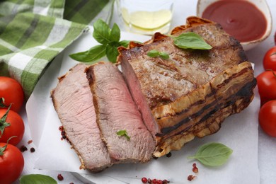 Photo of Delicious baked beef meat, tomatoes, spices and water with lime on table, above view
