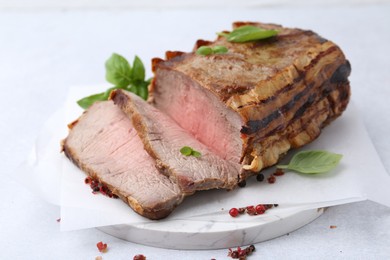 Photo of Delicious baked beef meat and spices on light table, closeup