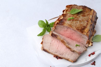 Photo of Delicious baked beef meat and spices on light table, closeup. Space for text