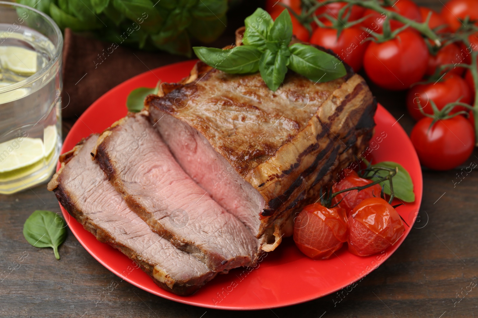 Delicious baked beef meat, tomatoes, basil and refreshing drink on wooden table, closeup Photo of Delicious baked beef meat, tomatoes, basil and refreshing drink on wooden table, closeup