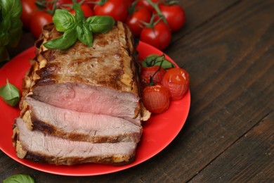 Photo of Delicious baked beef meat, tomatoes and basil on wooden table, closeup. Space for text