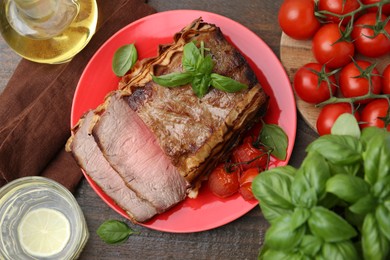 Photo of Delicious baked beef meat, tomatoes, basil and refreshing drink on wooden table, flat lay