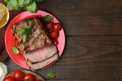 Photo of Delicious baked beef meat, tomatoes and basil on wooden table, flat lay. Space for text