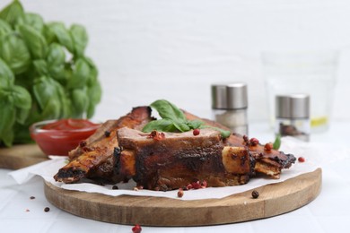 Photo of Roasted beef ribs with spices and ketchup on white table, closeup
