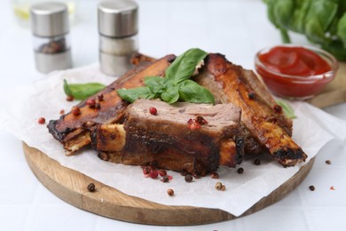 Photo of Roasted beef ribs with spices and ketchup on white table, closeup