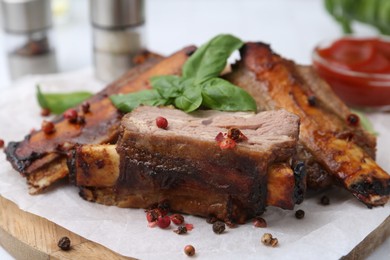 Photo of Roasted beef ribs with spices and ketchup on table, closeup