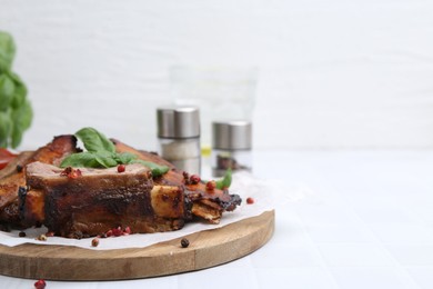 Photo of Roasted beef ribs with spices and ketchup on white tiled table, closeup. Space for text