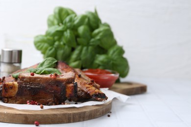 Photo of Roasted beef ribs with spices and ketchup on white tiled table, closeup. Space for text