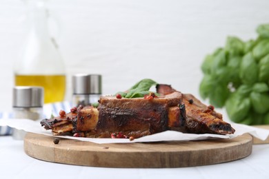 Photo of Roasted beef ribs with spices on white table, closeup