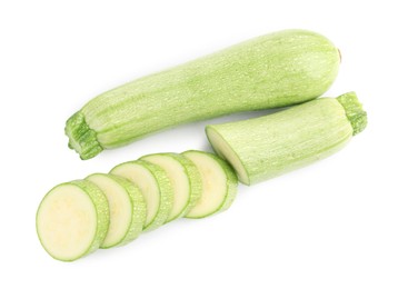 Photo of Fresh whole and cut zucchinis isolated on white, top view