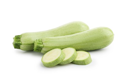 Photo of Fresh whole and cut zucchinis isolated on white