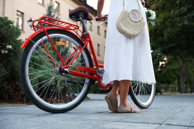 Photo of Woman near bicycle on city street, closeup