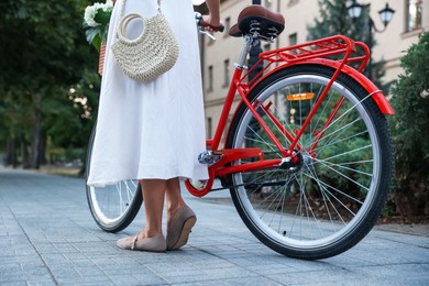 Photo of Woman near bicycle on city street, closeup