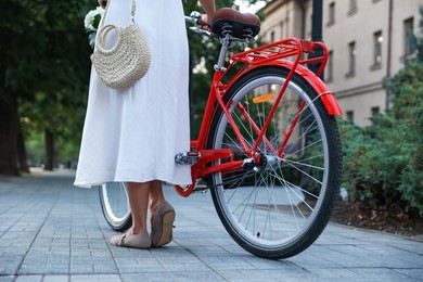 Photo of Woman near bicycle on city street, closeup