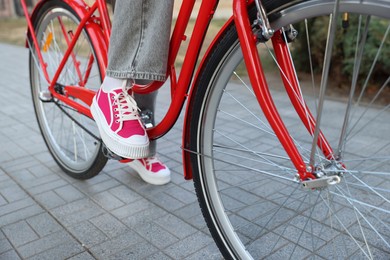 Photo of Teenage girl riding bicycle on city street, closeup